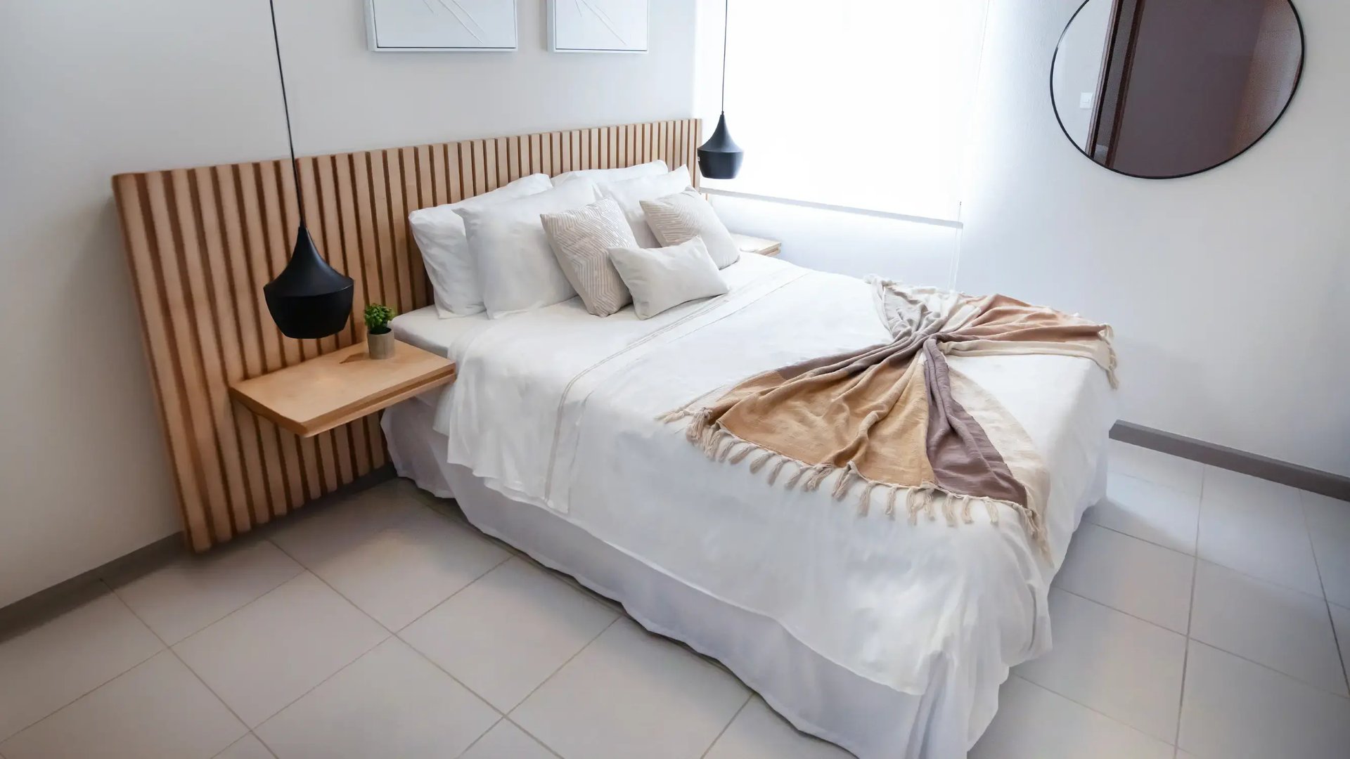 Render de dormitorio moderno en Condominio Nova, Desamparados. Muestra cama queen con edredón blanco, mesitas de noche de madera, lámparas colgantes y un amplio ventanal.