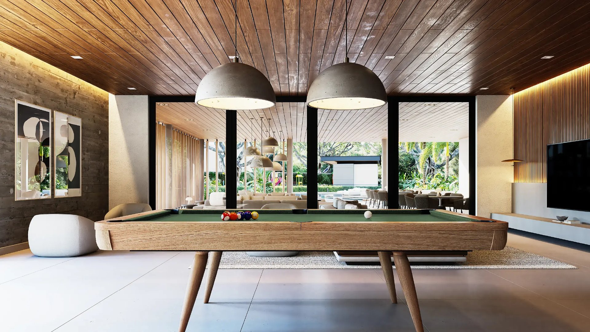 Render de sala de juegos en Casa Club. Incluye mesa de billar de madera, lámparas colgantes modernas, cielorraso de madera e iluminación cálida. Al fondo se observa el área social y vistas al jardín.