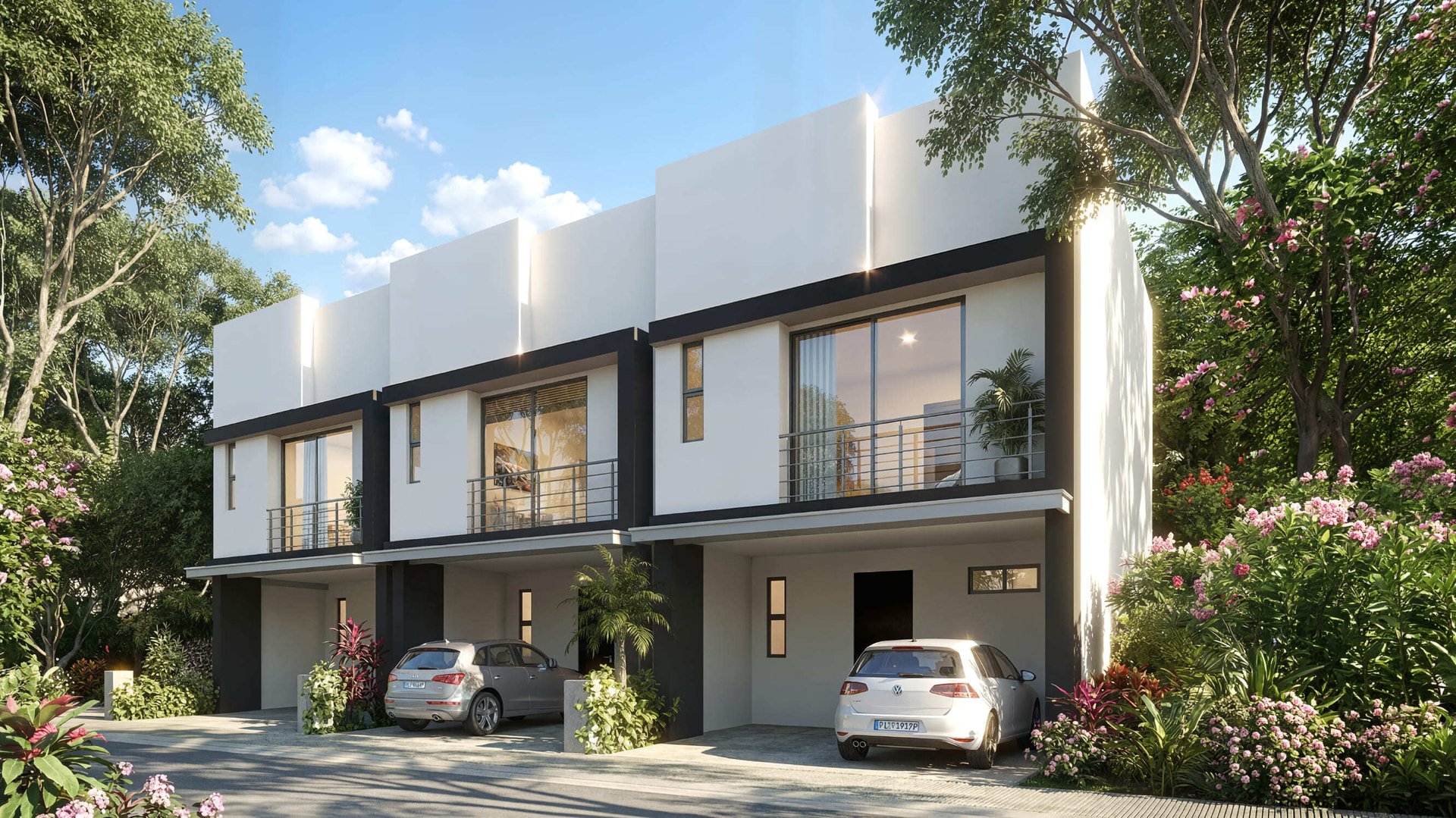 Fachada exterior de casas modernas de dos pisos con acabados en blanco y negro, balcones de cristal y metal, cocheras con automóviles estacionados y jardines floridos.