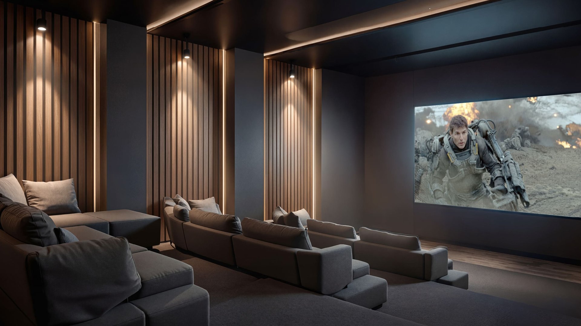 Sala de cine privada o home theater de lujo con filas de sofás grises, paredes con paneles de madera e iluminación tenue, proyectando una película de acción en una gran pantalla.