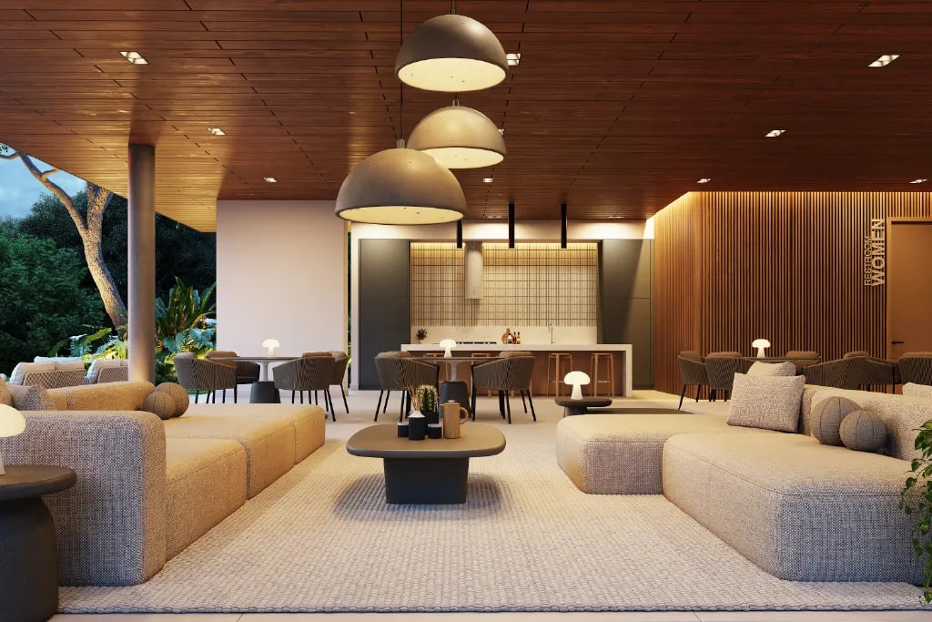 Render de casa club moderna con concepto abierto. Incluye una amplia sala con sofás minimalistas, mesas de comedor, cielorraso de madera con iluminación cálida, lámparas colgantes y una cocina social al fondo con acabados de lujo.